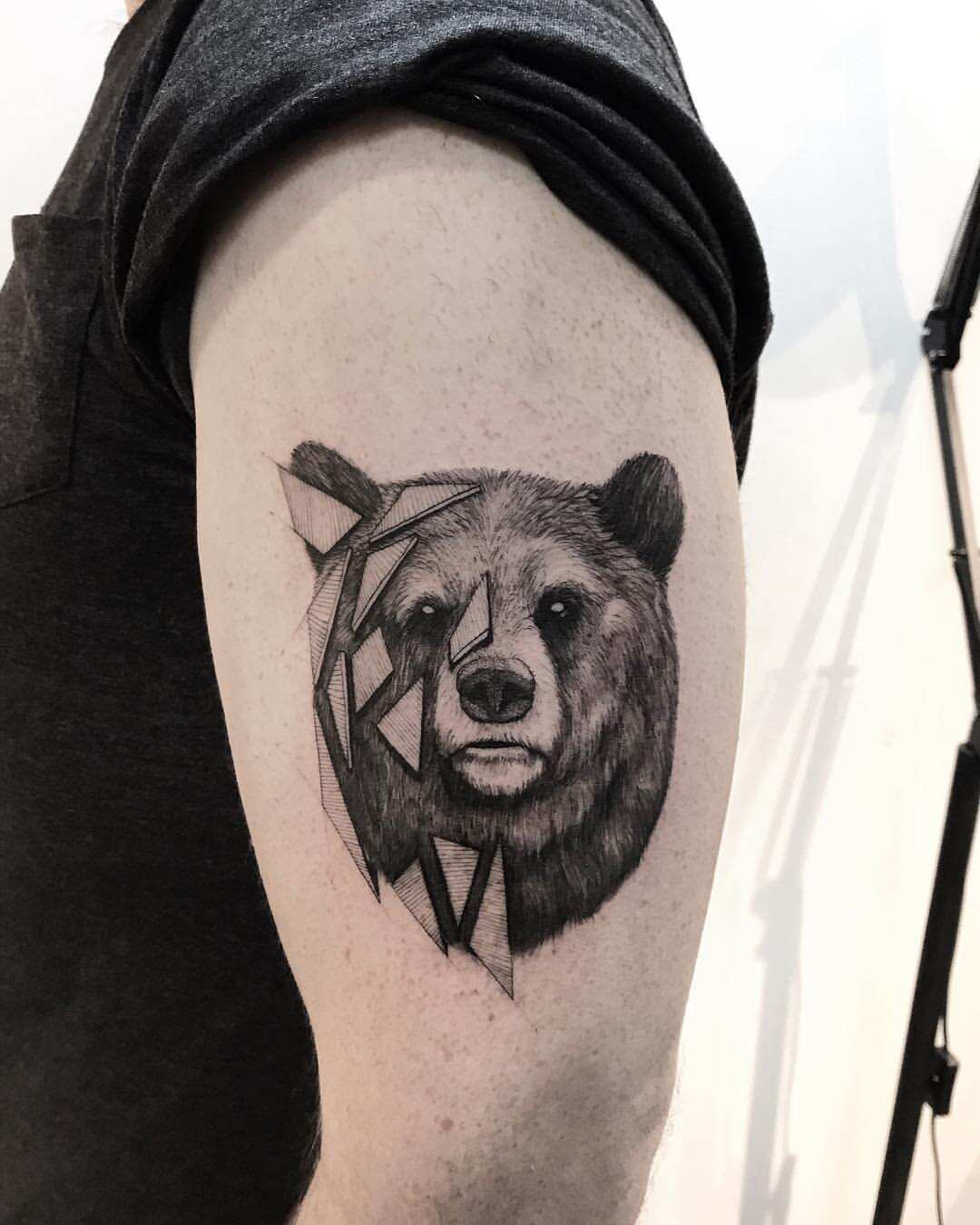 Upper arm tattoo, portrait of a black bear wearing a flower crown of  mountain laurel flowers, surrounded by ferns, with cedar trees in the  background, colorful art nouveau tattoo style on Craiyon